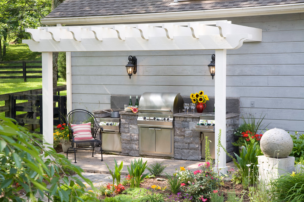 Idées déco pour un porche d'entrée de maison classique avec une cuisine d'été, des pavés en pierre naturelle et une pergola.