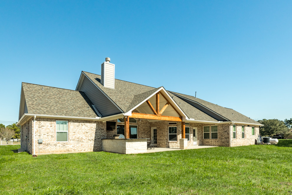 Immagine di un grande portico american style dietro casa con lastre di cemento e un tetto a sbalzo