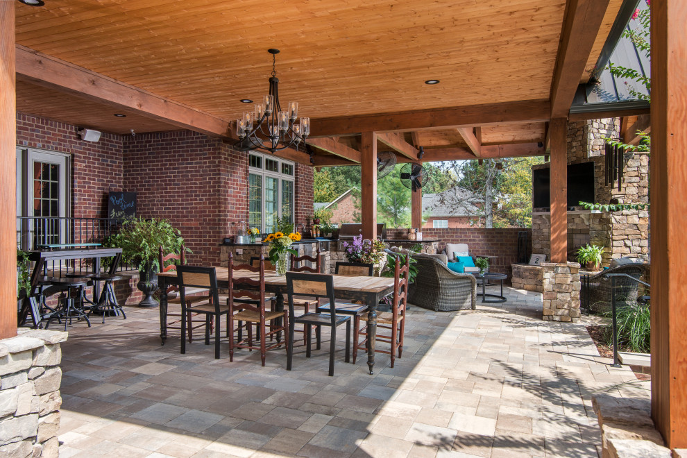 Photo of a large rustic back patio in Nashville with an outdoor kitchen and a roof extension.