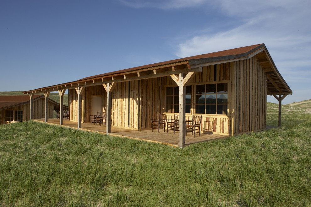 Aménagement d'un porche d'entrée de maison montagne de taille moyenne avec une terrasse en bois et une extension de toiture.