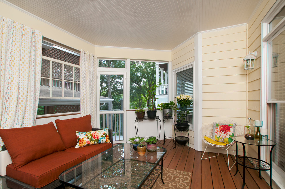 This is an example of a huge transitional screened-in side porch design in Atlanta with decking and a roof extension.