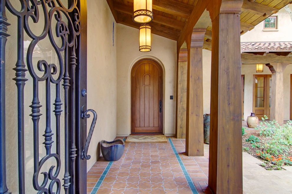 Источник вдохновения для домашнего уюта: большая веранда на переднем дворе в средиземноморском стиле с покрытием из плитки и навесом