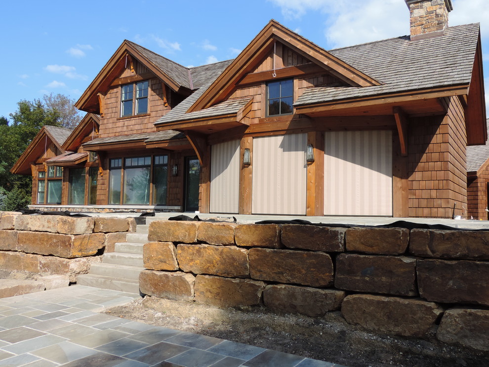 Diseño de porche cerrado rústico extra grande en patio trasero y anexo de casas con adoquines de piedra natural