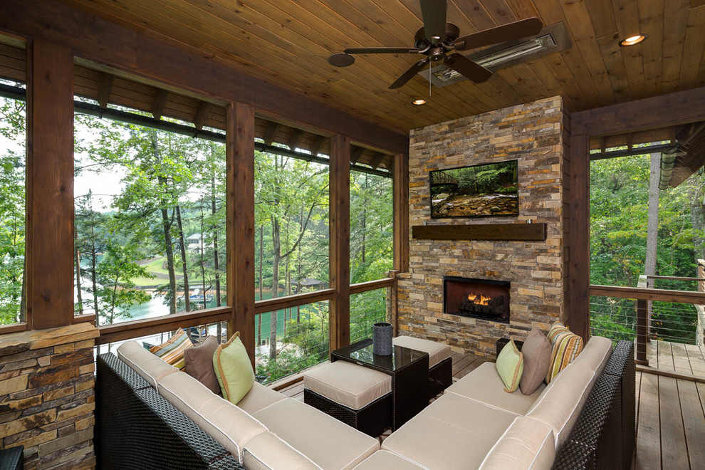 Aménagement d'un porche d'entrée de maison montagne avec un foyer extérieur, une terrasse en bois et une extension de toiture.
