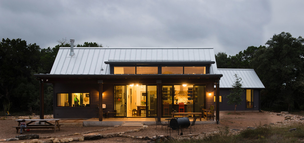 Große, Überdachte Landhausstil Veranda hinter dem Haus mit Natursteinplatten in Austin