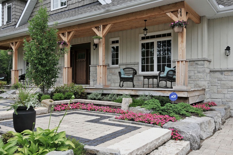 Idee per un portico american style di medie dimensioni e davanti casa con pavimentazioni in pietra naturale e un tetto a sbalzo