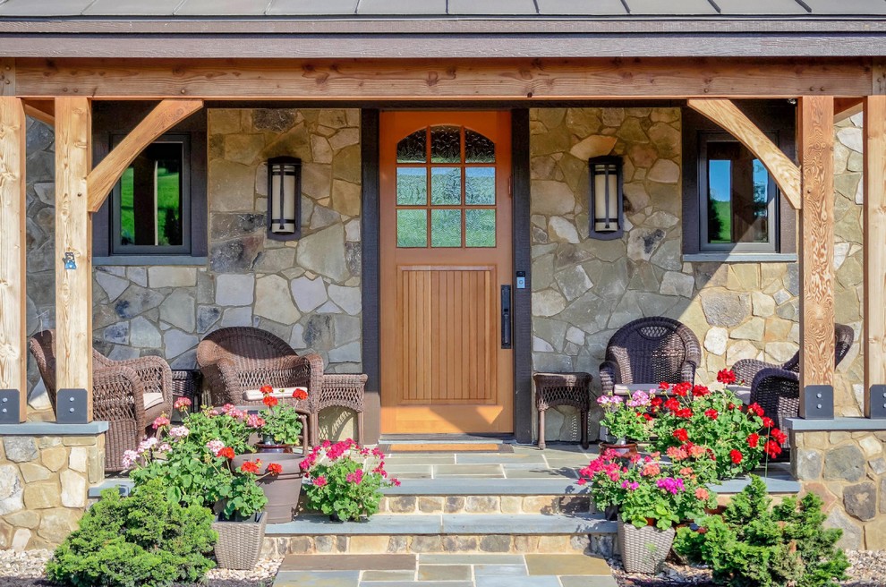 Inspiration for a mid-sized rustic stone front porch remodel in Other