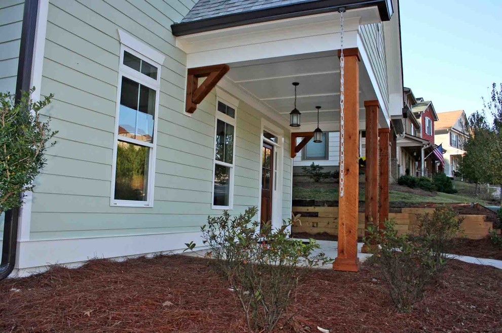 Пример оригинального дизайна: веранда среднего размера на переднем дворе в стиле кантри с покрытием из бетонных плит и навесом
