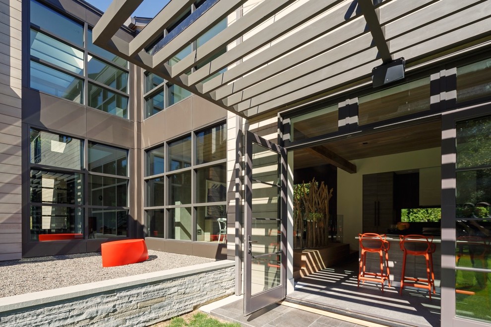 Ispirazione per un ampio portico minimalista nel cortile laterale con pavimentazioni in pietra naturale e una pergola