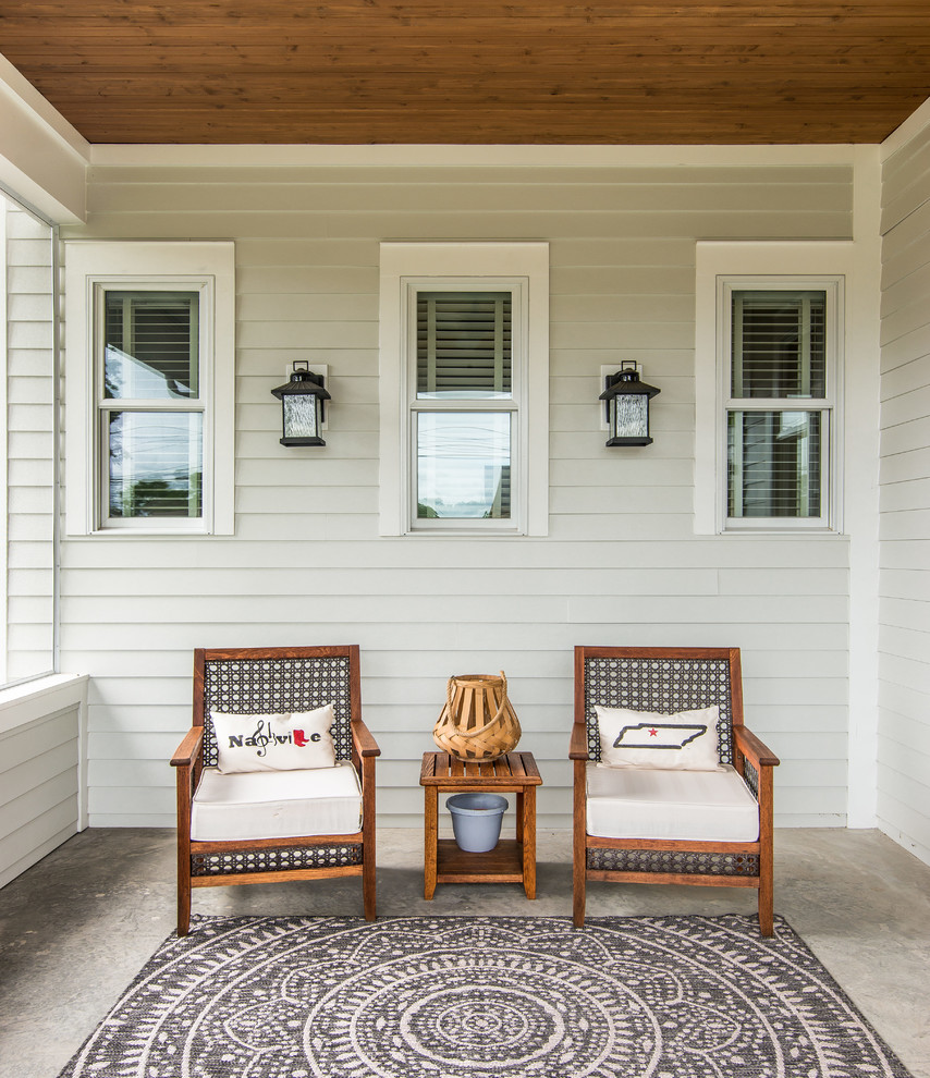 Exemple d'un porche d'entrée de maison avant craftsman de taille moyenne avec une moustiquaire, une dalle de béton et une extension de toiture.