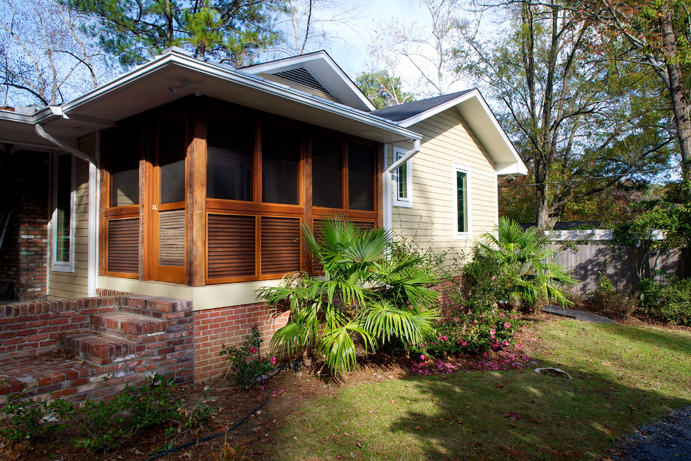 Inspiration for a mid-sized contemporary brick screened-in side porch remodel in Jackson with a roof extension