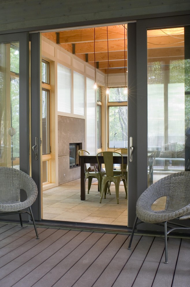 Cette image montre un porche d'entrée de maison minimaliste avec une terrasse en bois.