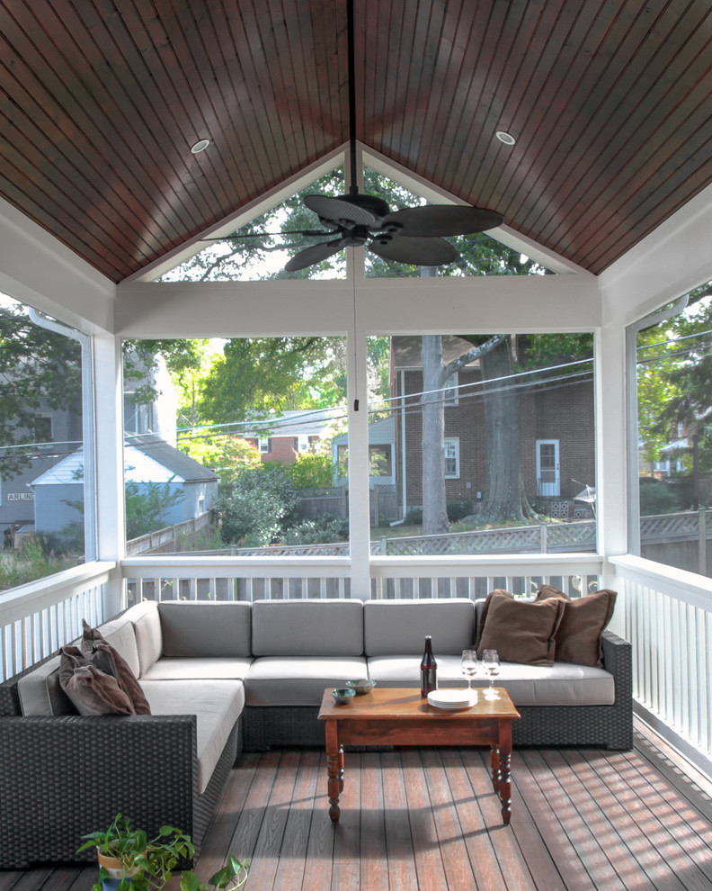 Cette image montre un grand porche d'entrée de maison arrière traditionnel avec une moustiquaire, une terrasse en bois et une extension de toiture.