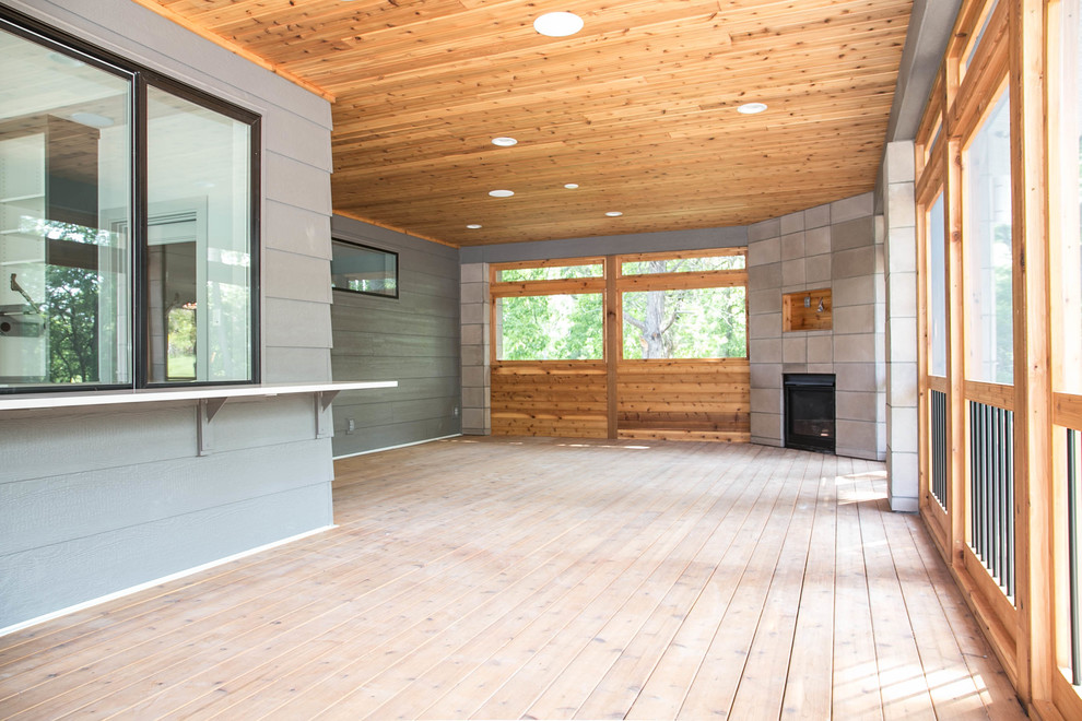 Inspiration pour un porche d'entrée de maison arrière design avec une moustiquaire, une terrasse en bois et une extension de toiture.