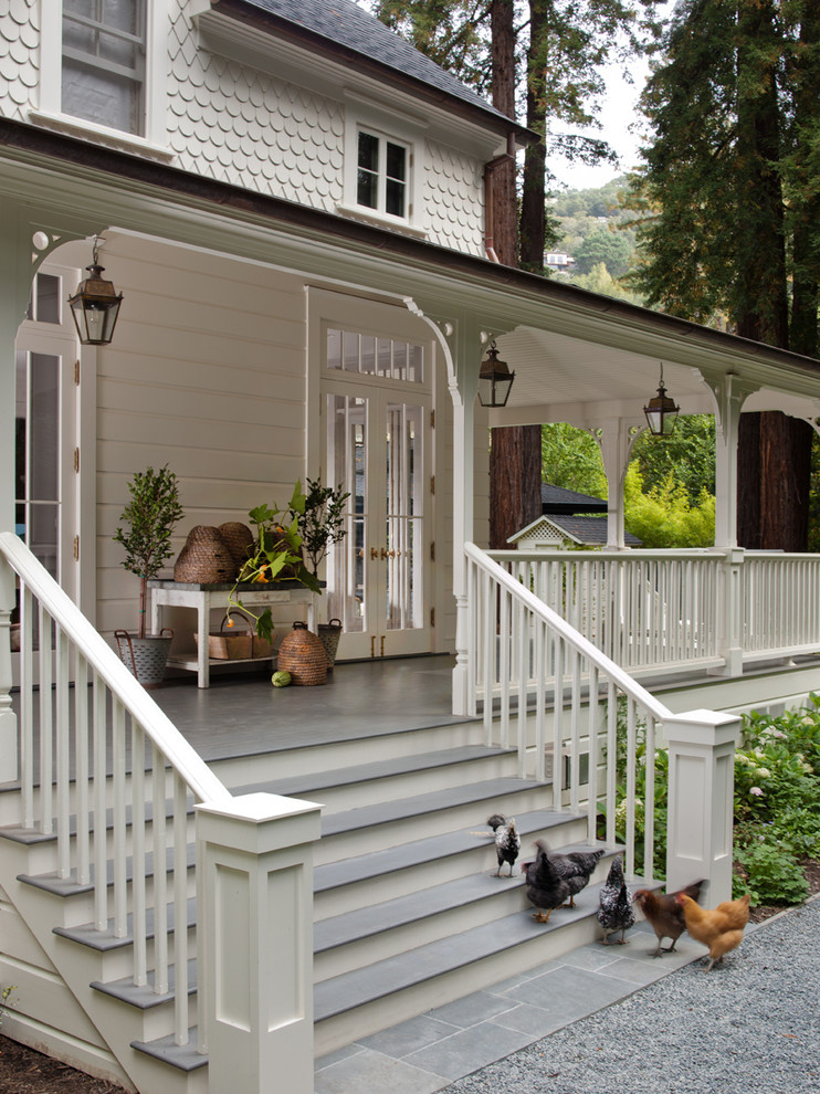 Esempio di un portico classico davanti casa con un tetto a sbalzo e un giardino in vaso