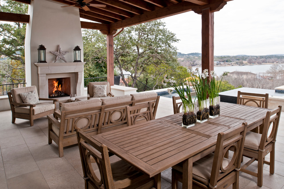 Inspiration for a mediterranean porch remodel in Austin with a fire pit and a roof extension