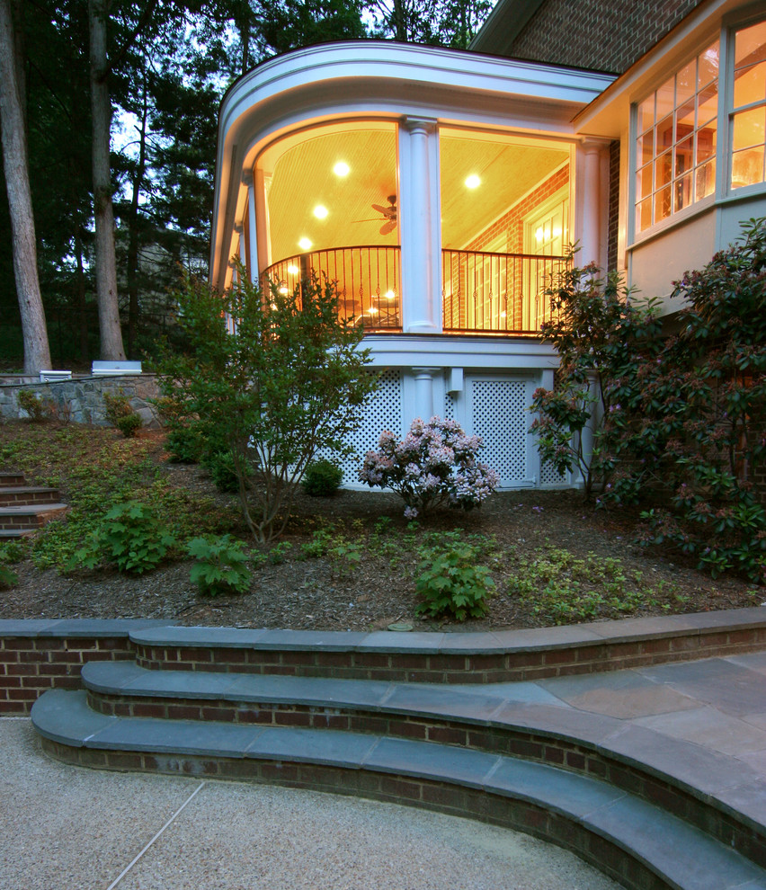 Inspiration för en stor vintage innätad veranda på baksidan av huset, med trädäck och takförlängning