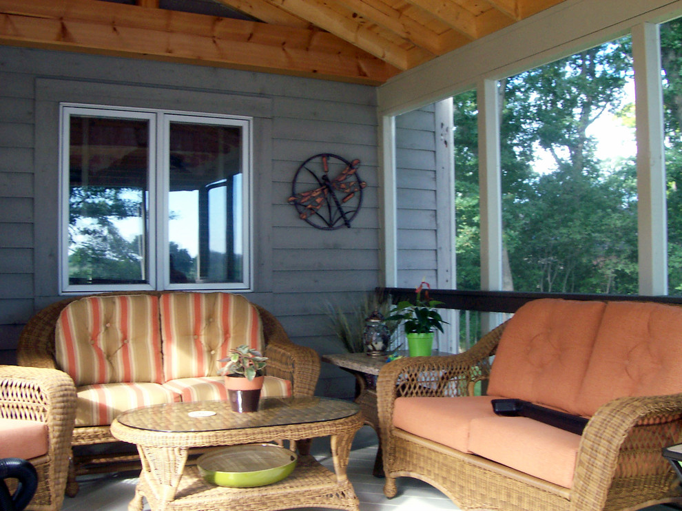 Ejemplo de porche cerrado tradicional grande en patio trasero y anexo de casas con adoquines de ladrillo