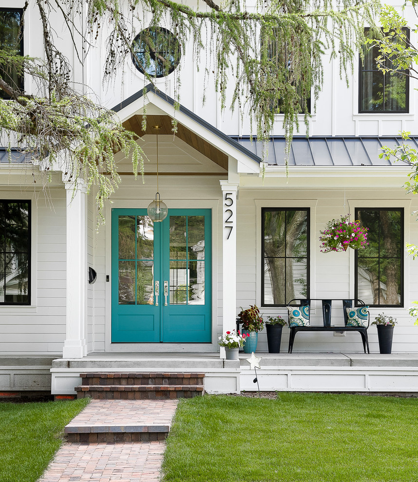 This is an example of a country concrete porch container garden design in Chicago with a roof extension.