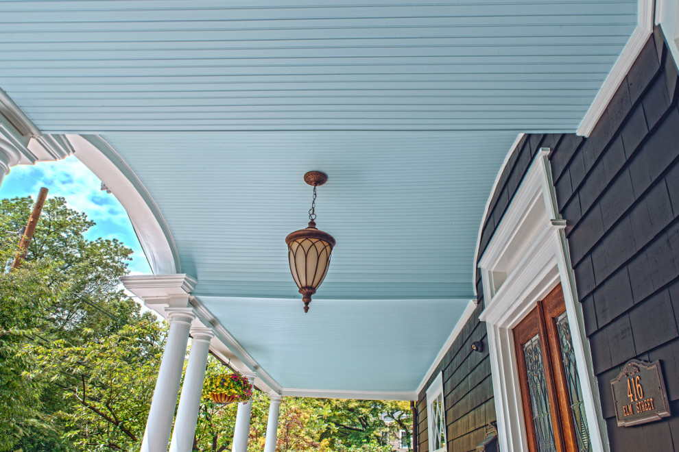 Ornate front porch photo in New York with a roof extension