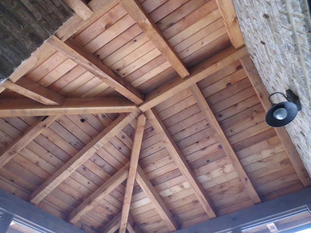 Exemple d'un porche d'entrée de maison latéral montagne de taille moyenne avec une moustiquaire, des pavés en béton et une extension de toiture.