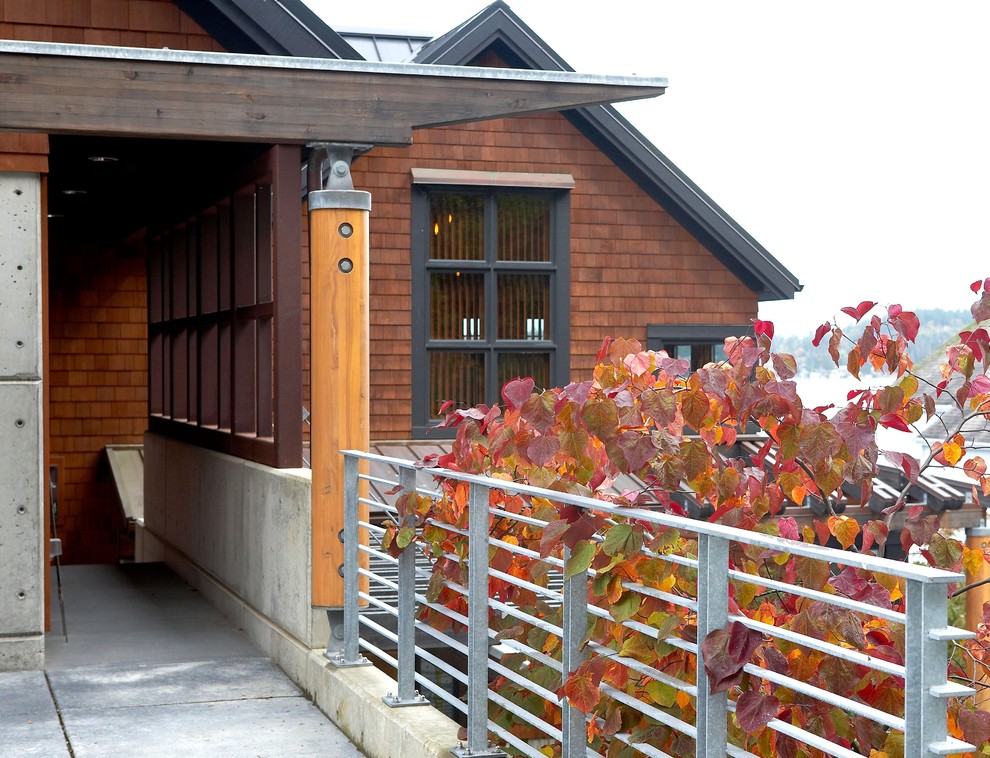 Esempio di un grande portico tradizionale davanti casa con un tetto a sbalzo e lastre di cemento