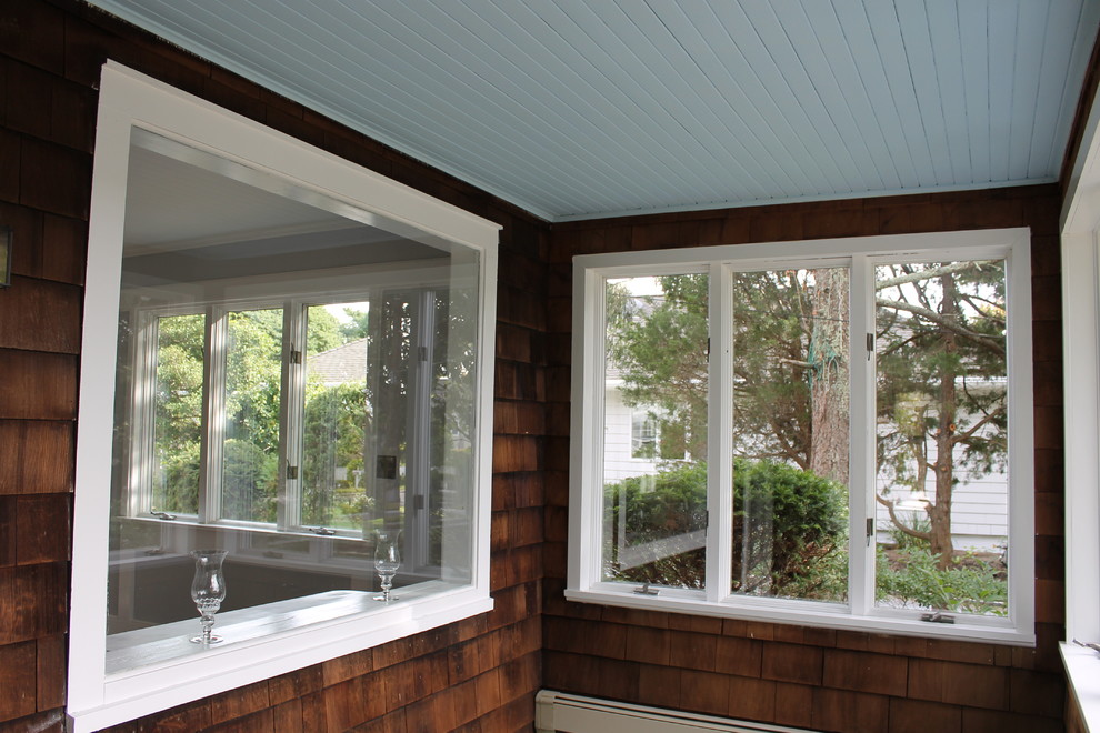 Exemple d'un porche d'entrée de maison avant bord de mer de taille moyenne avec une moustiquaire, une dalle de béton et une extension de toiture.