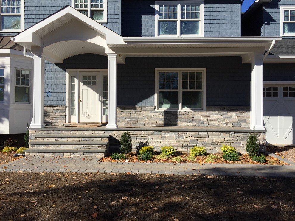 Cette photo montre un porche d'entrée de maison avant craftsman de taille moyenne avec des pavés en béton.