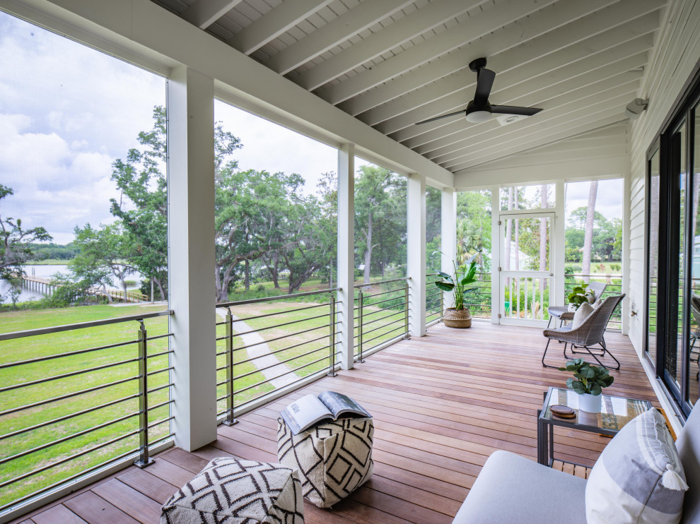 Aménagement d'un porche d'entrée de maison arrière bord de mer avec une moustiquaire et une terrasse en bois.