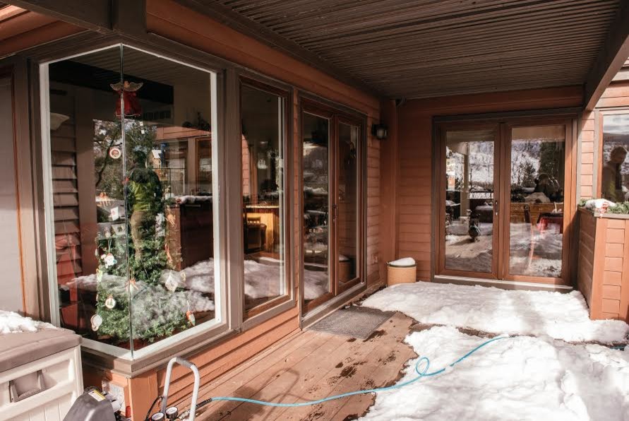 Aménagement d'un porche d'entrée de maison arrière craftsman de taille moyenne avec une terrasse en bois et une extension de toiture.