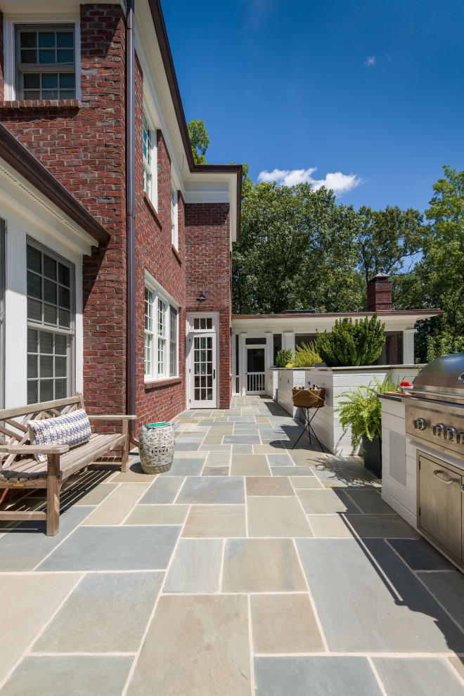 Idee per un grande patio o portico classico dietro casa con pavimentazioni in pietra naturale e un tetto a sbalzo