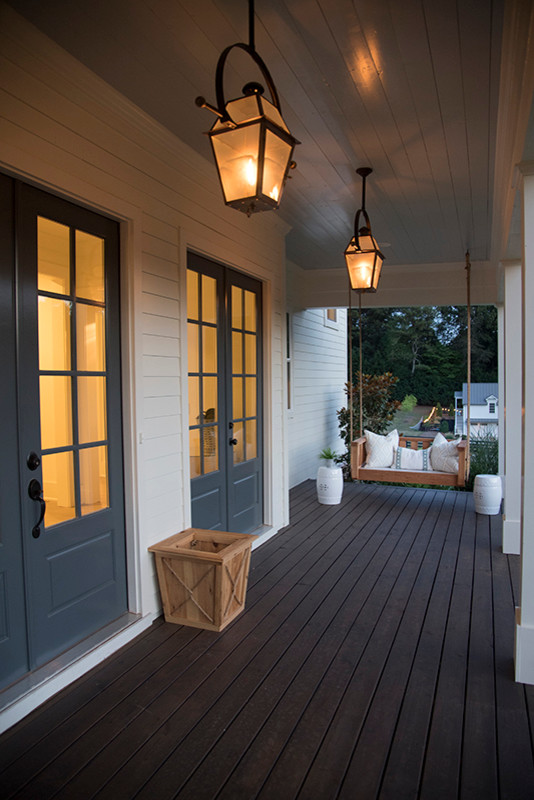 Photo of a medium sized rural front veranda in Atlanta with decking, a roof extension and feature lighting.