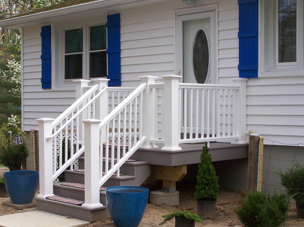 This is an example of a small tropical front porch design in New York with decking.
