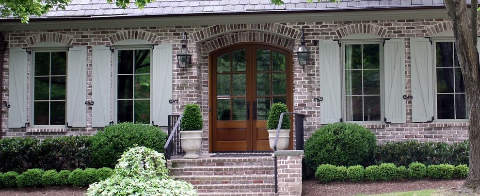 Small elegant brick front porch photo in Nashville with a roof extension