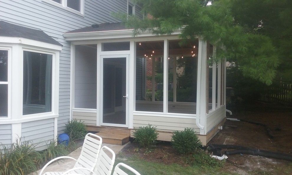 Mid-sized screened-in back porch photo in Chicago with decking and a roof extension