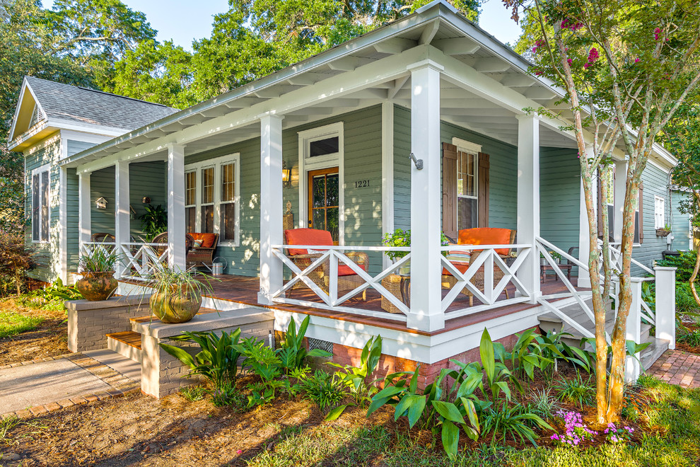 Design ideas for a large traditional front veranda in Miami with a roof extension, decking and feature lighting.