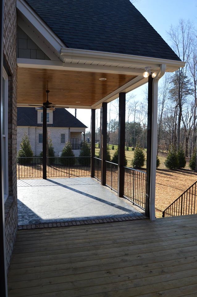 Inspiration pour un porche d'entrée de maison avant traditionnel de taille moyenne avec du béton estampé et une extension de toiture.