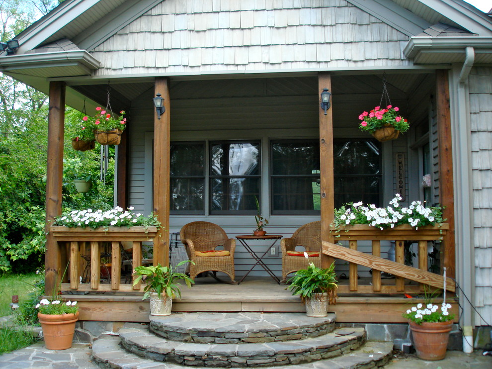 Aménagement d'un porche d'entrée de maison avant classique avec une terrasse en bois et une extension de toiture.