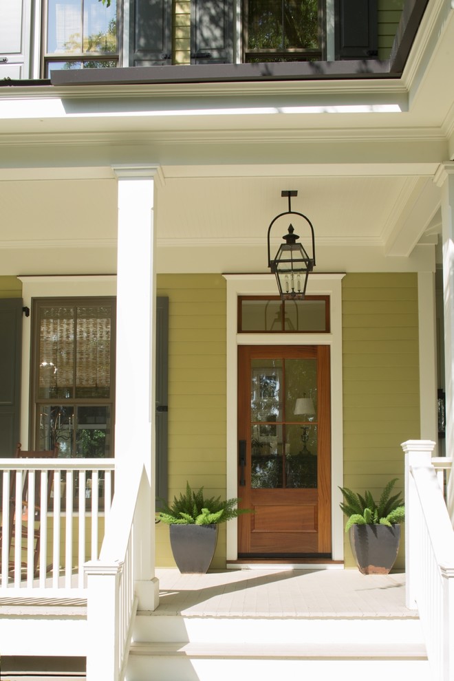 Aménagement d'un porche d'entrée de maison avant craftsman de taille moyenne avec une terrasse en bois et une extension de toiture.