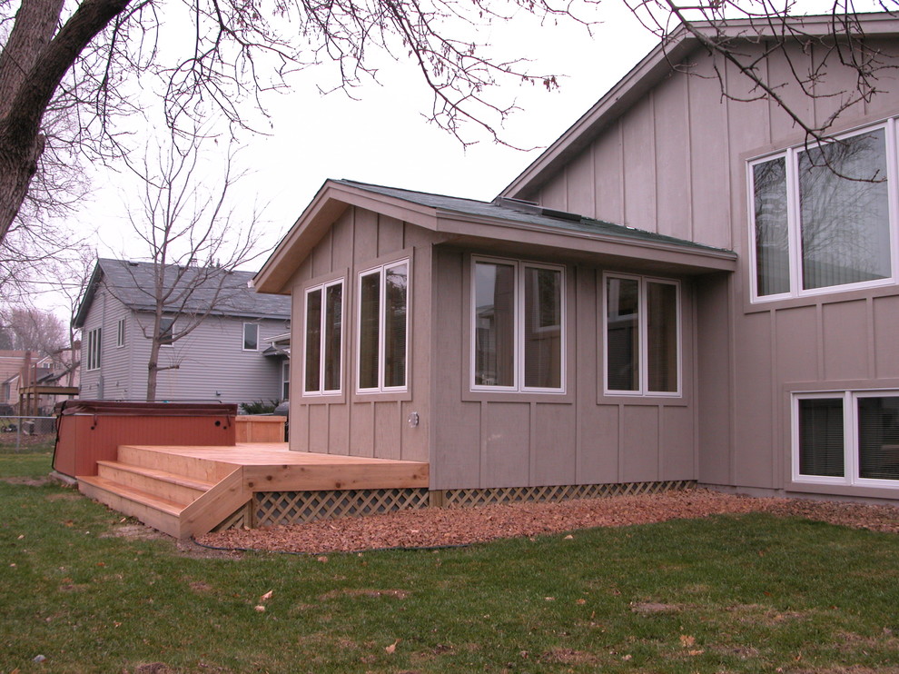 Cette image montre un petit porche d'entrée de maison arrière traditionnel avec un point d'eau, une terrasse en bois et une extension de toiture.