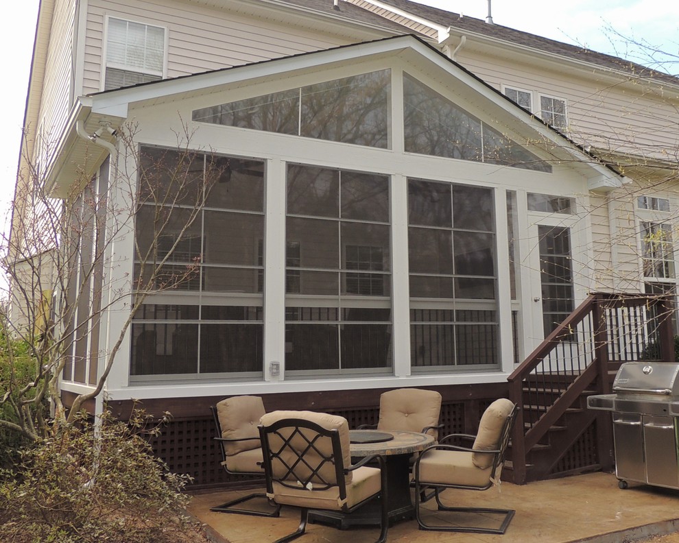 This is an example of a mid-sized traditional screened-in back porch design in Charlotte with decking and a roof extension.