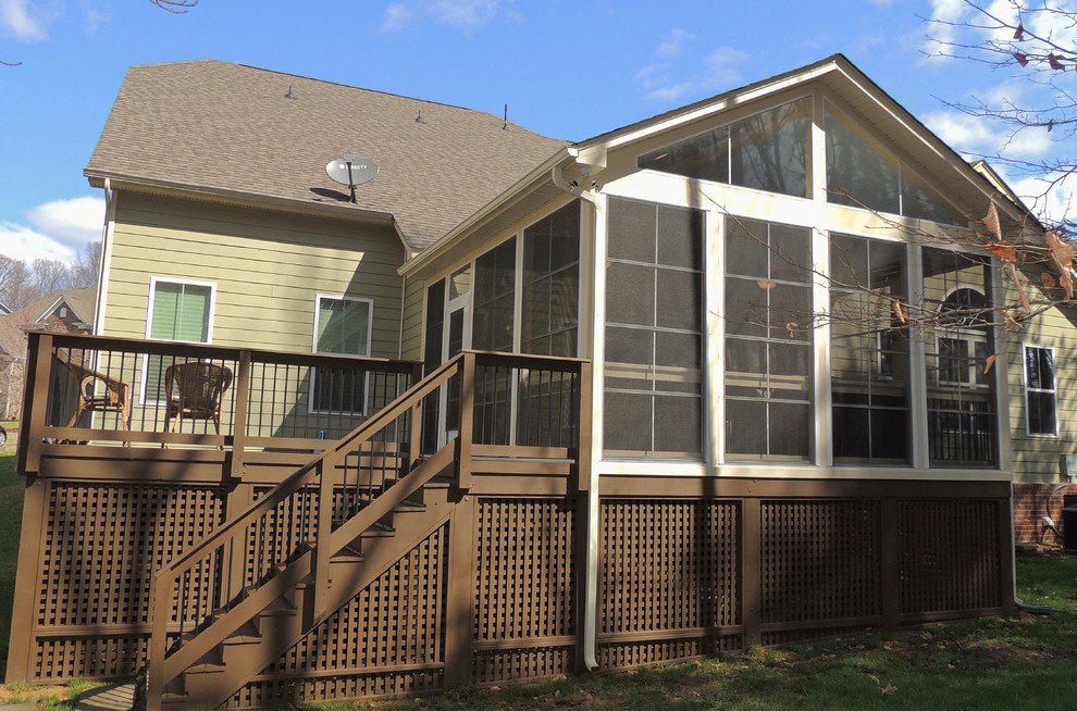 Large classic screened-in back porch idea in Charlotte with decking and a roof extension