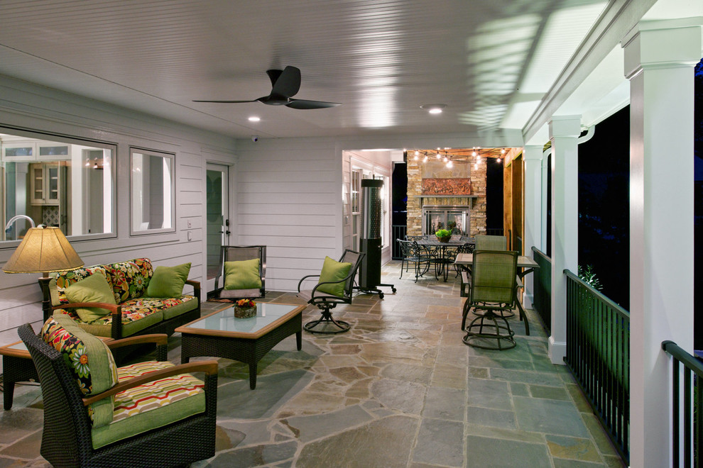 Réalisation d'un grand porche d'entrée de maison arrière tradition avec des pavés en pierre naturelle et une extension de toiture.