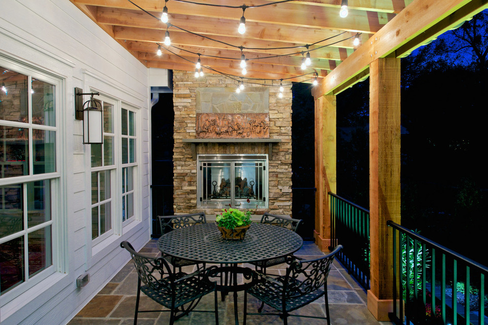 Imagen de terraza tradicional grande en patio trasero y anexo de casas con adoquines de piedra natural y iluminación