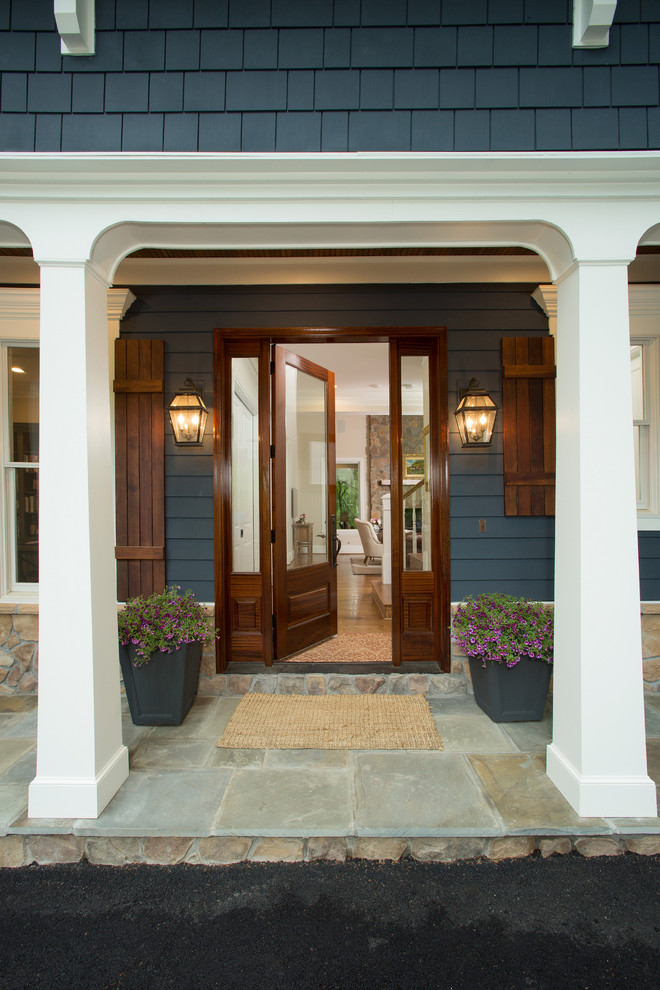 Foto di un piccolo portico stile americano davanti casa con pavimentazioni in pietra naturale e un tetto a sbalzo