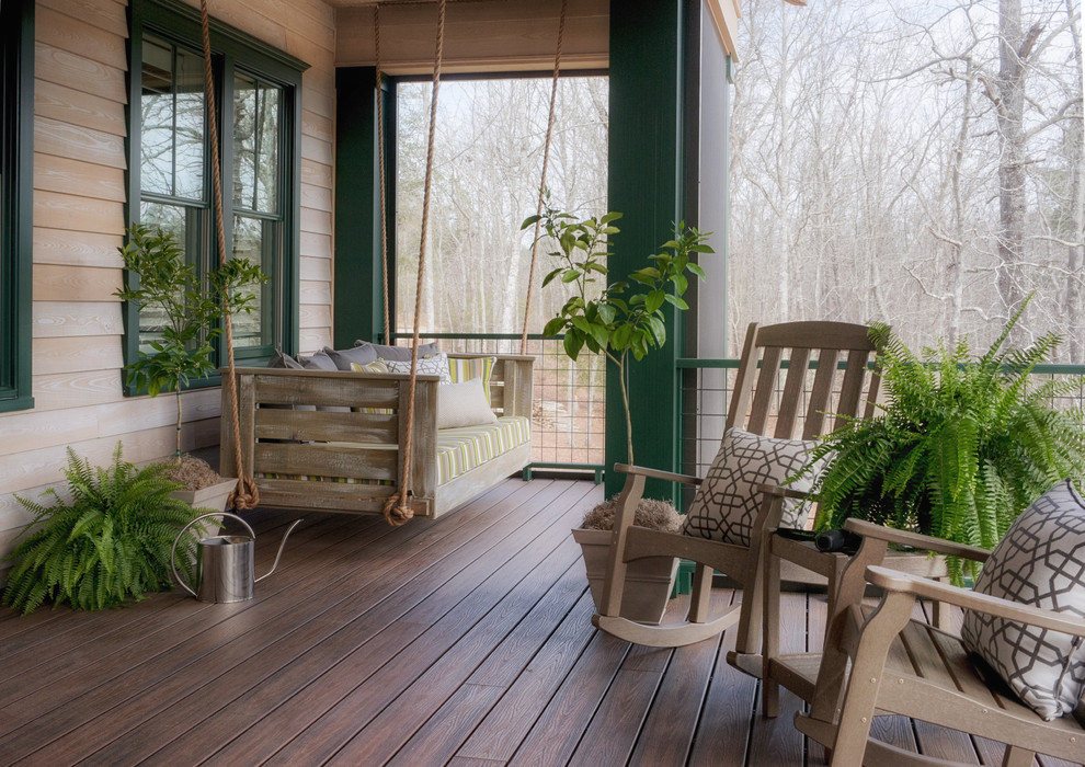This is an example of a large rustic porch design in Atlanta with a roof extension.