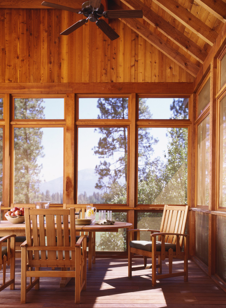 This is an example of a rustic screened-in porch design in San Francisco with decking and a roof extension.