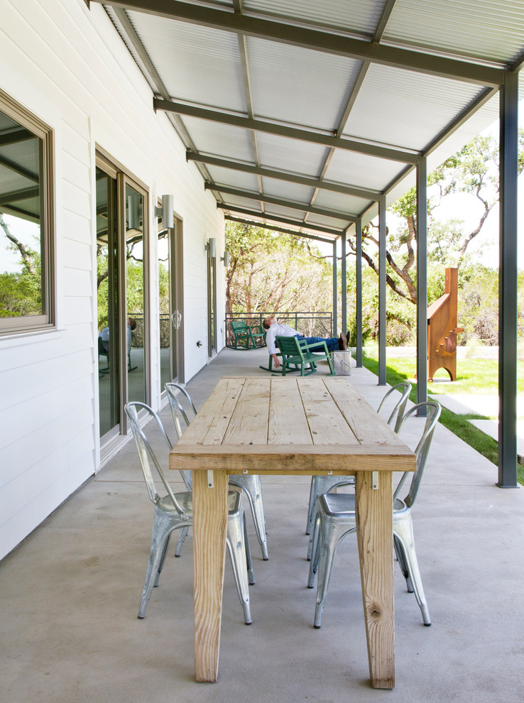 Farmhouse concrete porch photo in Austin with a roof extension