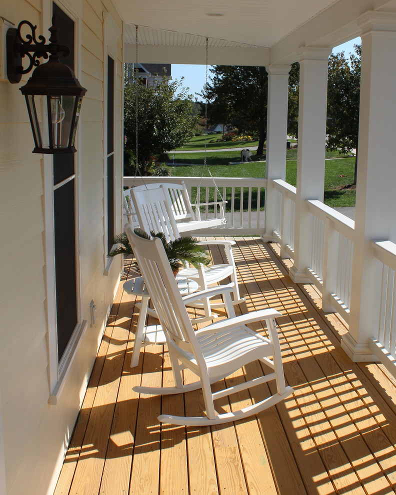 Inredning av en klassisk mellanstor veranda framför huset, med trädäck och takförlängning