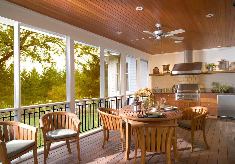 Cette photo montre un grand porche d'entrée de maison arrière chic avec une cuisine d'été, une terrasse en bois et une extension de toiture.